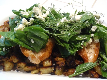 pea shoot salad over chicken and potatoes